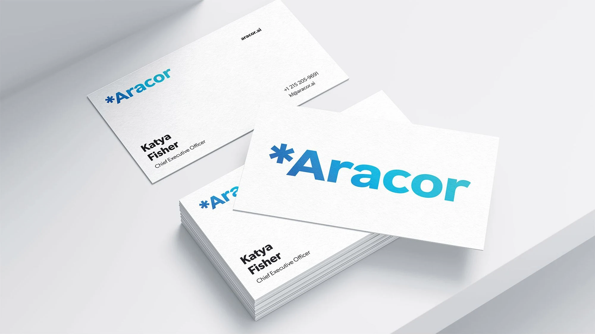 White Aracor business cards with the blue-to-cyan wordmark
